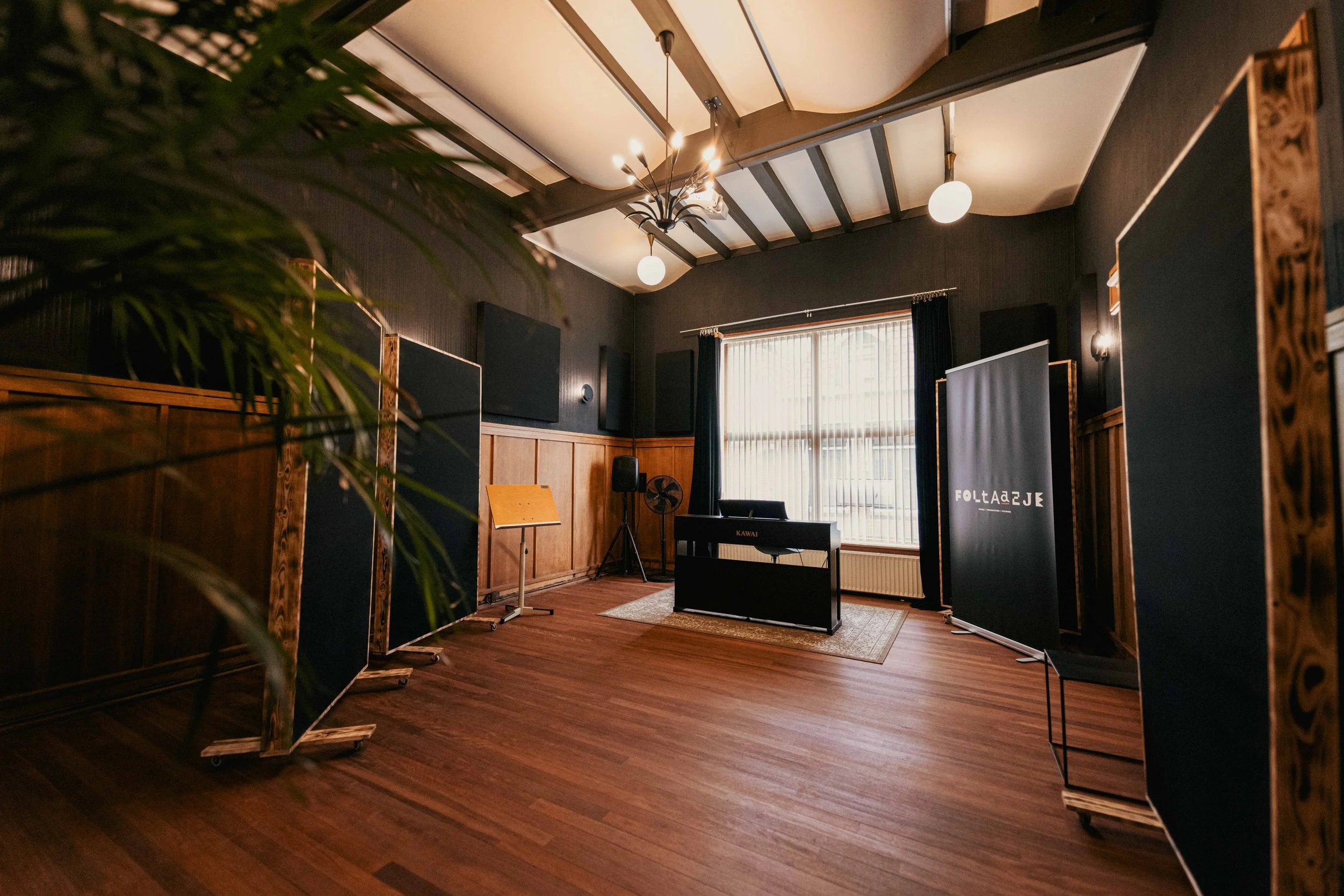 Liveroom 1 met een zwarte piano, akoestische panelen en daglicht