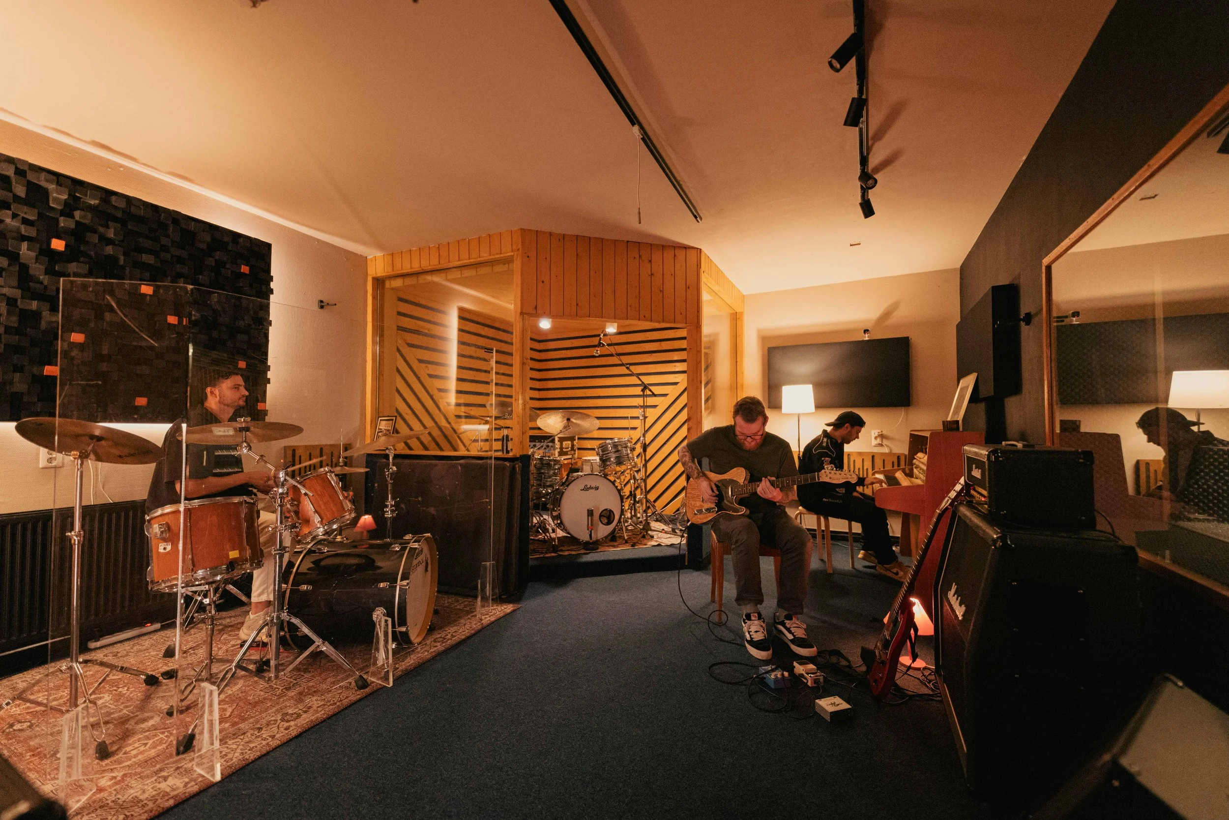 Een band repeteert in de tweede liveroom: drums, gitaar en keys