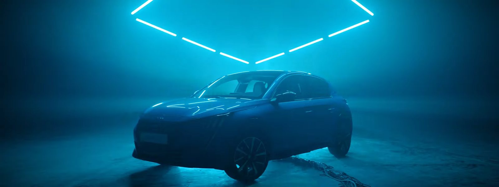 Een blauwe Peugeot 208 in een mistige ruimte onder blauwe neonlijnen